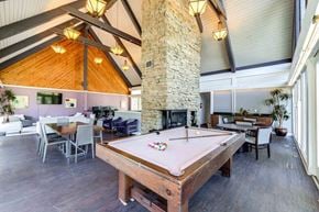 Indianapolis apartment for rent - Clubhouse interior with pool table and stone fireplace at Summit at Keystone Apartments, Indianapolis, 46220