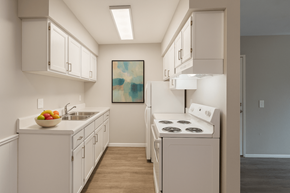 Oregon apartment for rent - A kitchen with white cabinets and a white stove top oven.