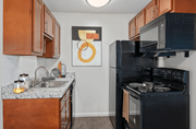 Fairfield apartment for rent - a kitchen with a black stove top oven next to a sink and a refrigerator at The Woodridge Collection, Ohio
