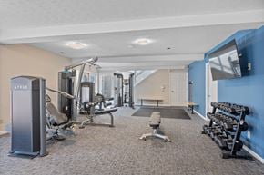 Centerville apartment for rent - A gym with a variety of equipment including weights and a bench.