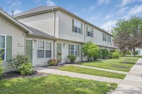 Cincinnati apartment for rent - A row of houses with green bushes in front.