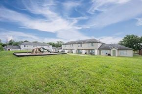 Cincinnati apartment for rent - A large grassy field with a playground and houses in the background.