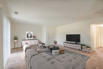 Indianapolis apartment for rent - A modern living room with a grey sofa and a flat screen TV.