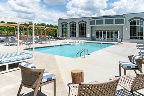 Cincinnati apartment for rent - a swimming pool with chairs and a building in the background at The Heights Apartments, Cincinnati, OH, 45220