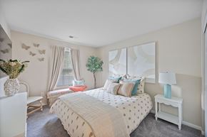 Maineville apartment for rent - A bedroom with a large bed and a white chair.