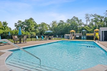 Resort style swimming pool is open to the community and is surrounded by deck chairs