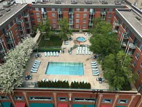 Cincinnati apartment for rent - An aerial view of a pool surrounded by sun loungers and trees.
