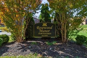 Louisville apartment for rent - A sign for Rosewood Manor Townhomes is surrounded by trees.