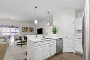 Covington apartment for rent - A modern kitchen with white cabinets and a large island. at Roebling Row, Covington, 41011-1720