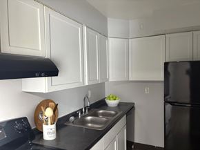 Dayton apartment for rent - A kitchen with black appliances and white cabinets.