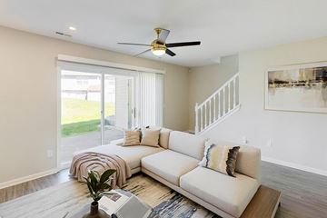 Beavercreek apartment for rent - A living room with a white couch and a ceiling fan.
