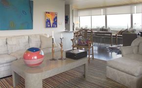 Cincinnati condo for rent - A living room with a couch, a table, and a painting on the wall.