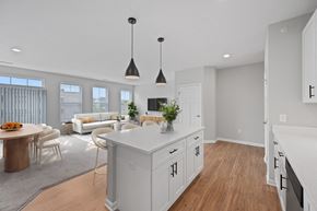 Newport apartment for rent - A modern kitchen with white cabinets and a wooden island. at Monmouth Row Apartments, Newport, KY, 41071