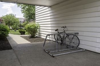 A bicycle parked on a bike rack on the side of a house