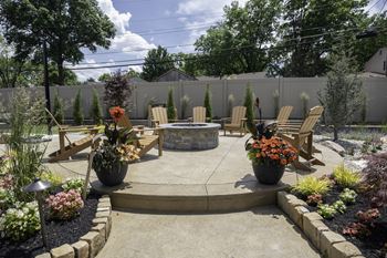 A patio with chairs and a fire pit