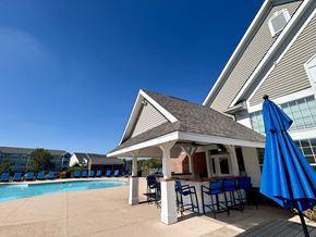 Maineville apartment for rent - A poolside bar area with a gazebo and blue umbrellas.