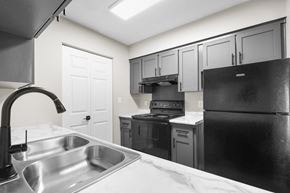 Columbus apartment for rent - A kitchen with a black refrigerator, sink, and cabinets.