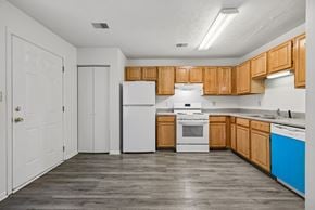 Cincinnati apartment for rent - A kitchen with wooden cabinets and white appliances.