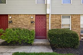 Columbus townhouse for rent - A red door is on the left side of a brick building. at Sharon Green Townhomes, Columbus, Ohio