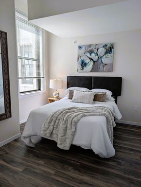 Cincinnati apartment for rent - A bedroom with a large bed and a painting on the wall.