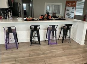 Columbus apartment for rent - Four black bar stools with purple cushions are placed in front of a bar.