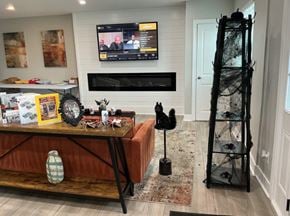 Columbus apartment for rent - A room with a television on the wall and a table with various objects on it.