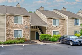 Beavercreek apartment for rent - a car parked in a parking lot in front of a building at Enclave, Ohio, 45431