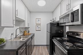 Batavia apartment for rent - Kitchen with white cabinetry and black appliances  at Timber Glen Apartments, Ohio