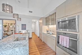 Cincinnati apartment for rent - A modern kitchen with a stainless steel oven and wooden floors at Sky Central Apartments, Cincinnati, 45202