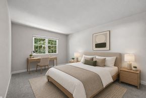 Cincinnati apartment for rent - A bedroom with a large bed and a desk with a chair.