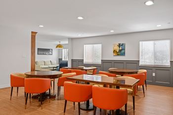 A room with a table and chairs and a couch in the background