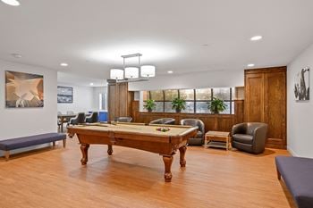 A game room with a pool table and chairs