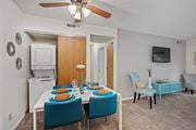 Fairfield apartment for rent - a dining area with a white table and blue chairs and a ceiling fan at The Woodridge Collection, Fairfield, OH 45014