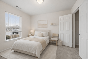 Columbus apartment for rent - A bedroom with a large bed and a window overlooking a parking lot.