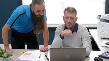 Two men looking at a laptop computer