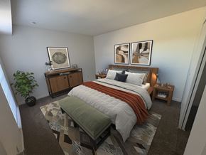 Dayton townhouse for rent - A bedroom with a bed, a bench, and a plant.