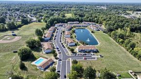 Lima apartment for rent - A bird's eye view of a residential area with a lake and a swimming pool.