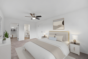 Dayton apartment for rent - a white bedroom with a large bed and a ceiling fan