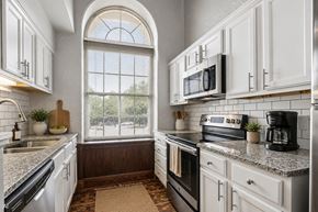 Dayton apartment for rent - A kitchen with white cabinets and a black stove top oven.