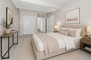Dayton apartment for rent - A bedroom with a large bed and a mirror on the wall.