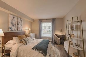 Indianapolis apartment for rent - A bedroom with a large bed and a window with a view of the street at A62 Apartments, Indianapolis, IN 46220