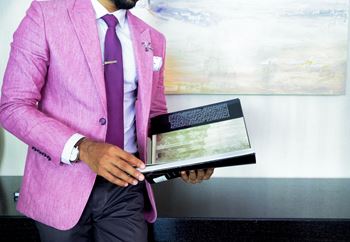 A man in a pink suit holding a book