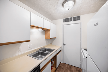 Cincinnati apartment for rent - A small kitchen with white cabinets and a white fridge.
