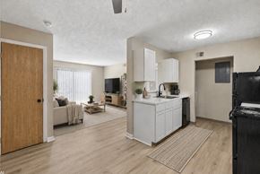 Findlay apartment for rent - A kitchen with white cabinets and a black fridge is shown.