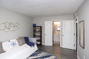 Indianapolis apartment for rent - A white couch with a blue throw is in a living room.