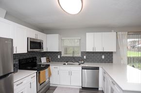 Indianapolis apartment for rent - A kitchen with white cabinets and a black stove top oven.at Spinnaker Court, Indianapolis Indiana