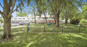 Bowling Green apartment for rent - a fenced in dog park with trees and a building in the background