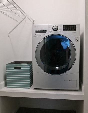 Washing machine sitting on a shelf in a room