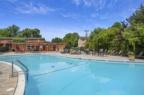 Alexandria apartment for rent - A large outdoor swimming pool surrounded by trees and lounge chairs at Rose Hill Apartments, Virginia