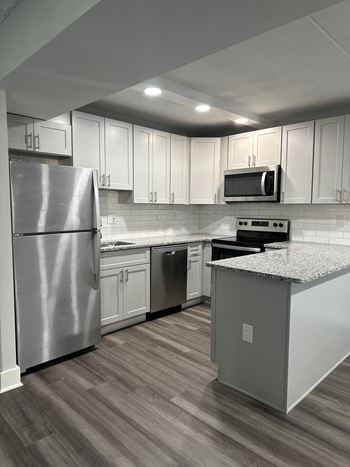 A kitchen with white cabinets and stainless steel appliances